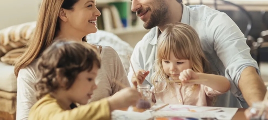 family-sitting-at-table-painting
